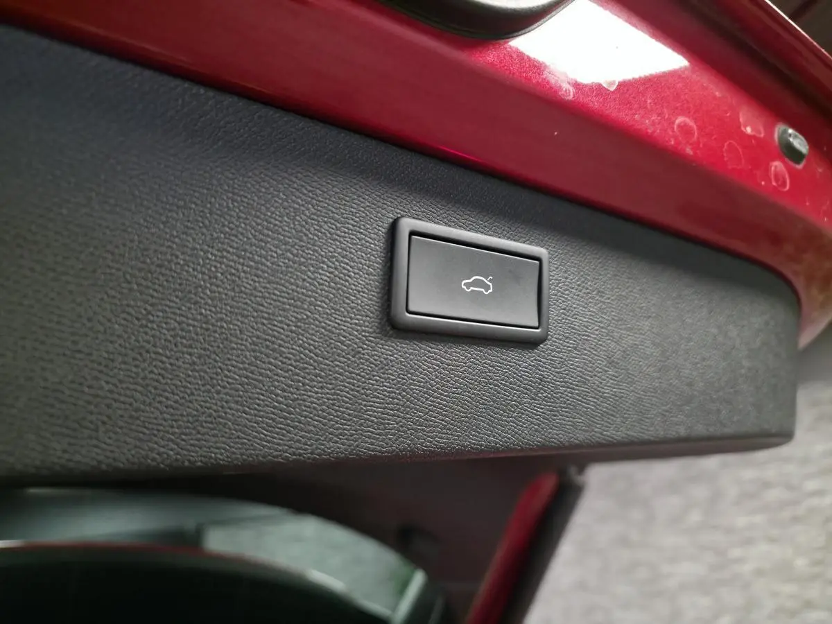 Bouton d'ouverture électrique du hayon sur la partie intérieure rouge vif du coffre arrière du CUPRA Formentor 2024.