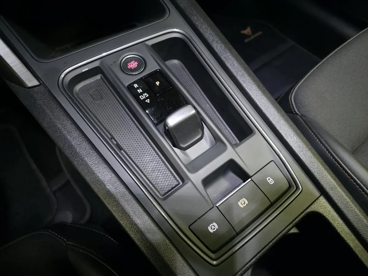 Vue rapprochée de la console centrale noire du Cupra Formentor 1.4 e-Hybrid avec levier de vitesses automatique et boutons lumineux.