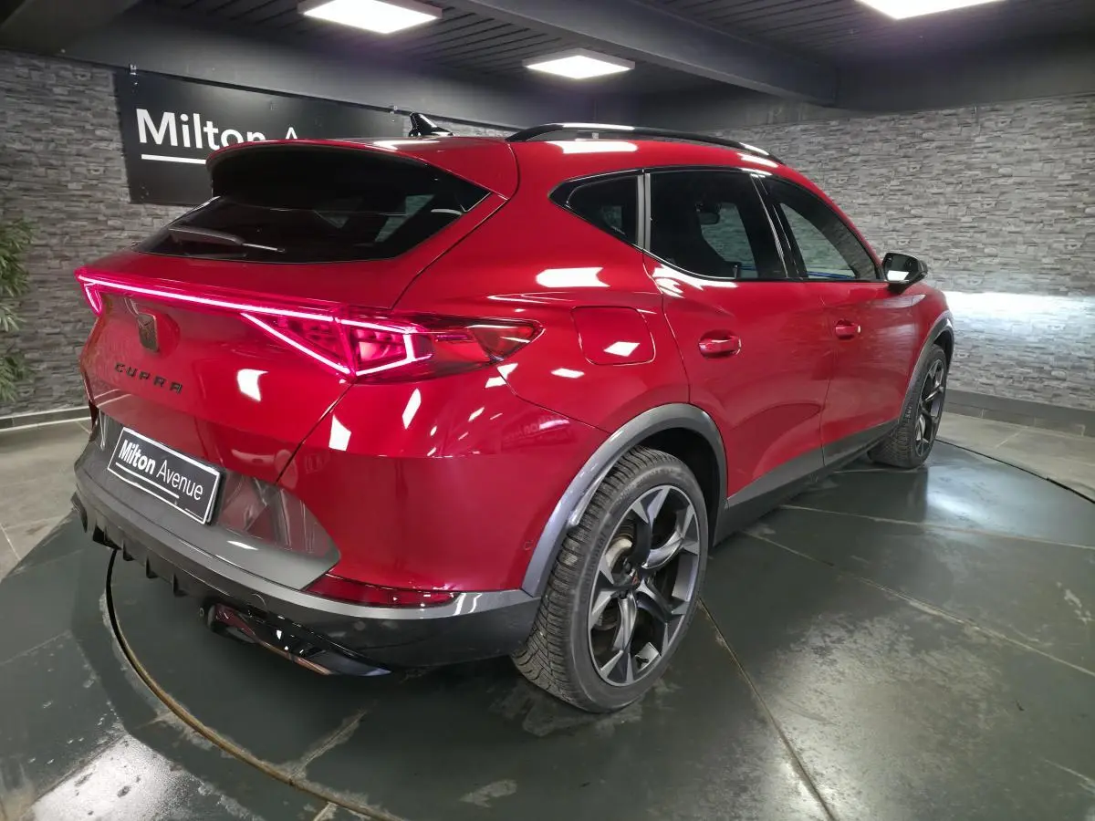 Vue 3/4 arrière droite du CUPRA Formentor rouge Désir 2024 avec bandeau LED arrière et jantes alliage noires.