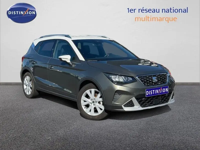 Vue 3/4 avant droite d'une SEAT Arona noir avec jantes alu et barres de toit blanches sur fond neutre.