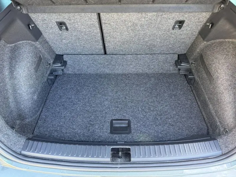 Vue plongeante sur le coffre spacieux et tapissé de tissu gris du SEAT Arona 2025, version essence noire.