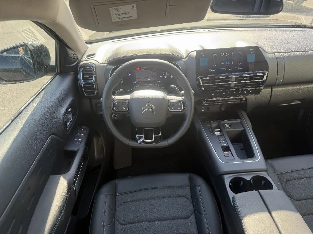 Vue intérieure frontale du tableau de bord et volant noir du Citroën C5 Aircross 2024 avec écran tactile et console centrale moderne.