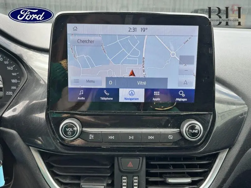 Écran tactile central montrant la navigation du Ford Puma 2022, avec commandes audio et climatisation en vue rapprochée
