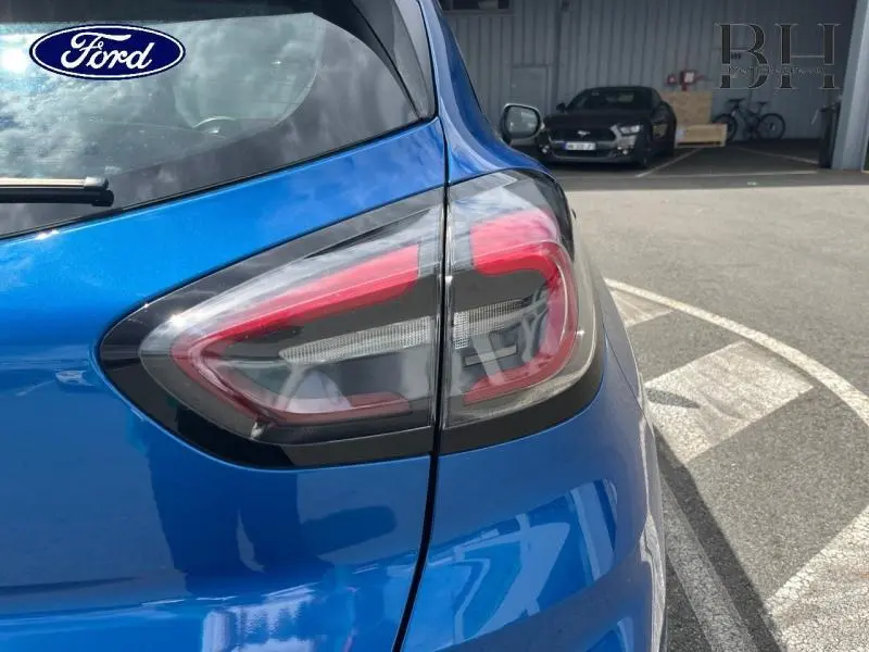 Gros plan sur le feu arrière droit d'une Ford Puma 2022 bleu Fashion Island métallisé, avec reflets et contours noirs.