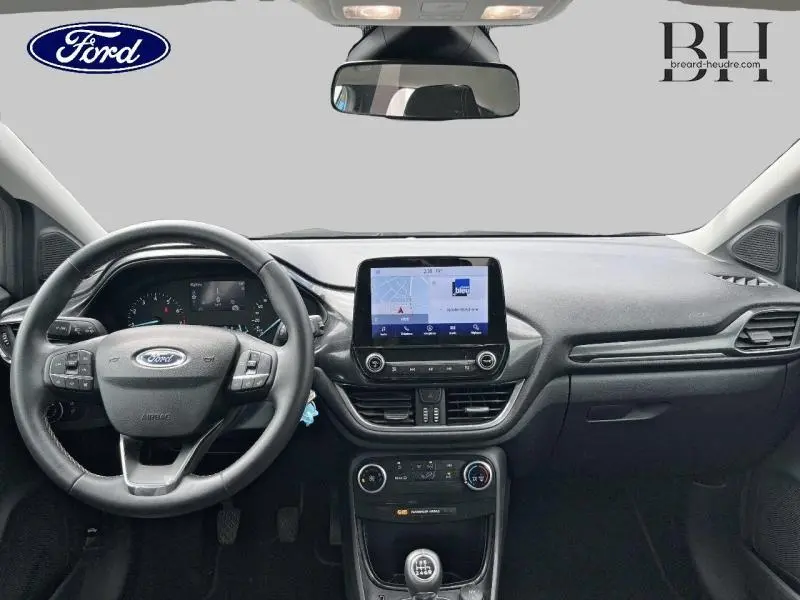 Vue frontale de l'habitacle du Ford Puma Titanium 2022 avec tableau de bord noir et écran tactile central allumé.
