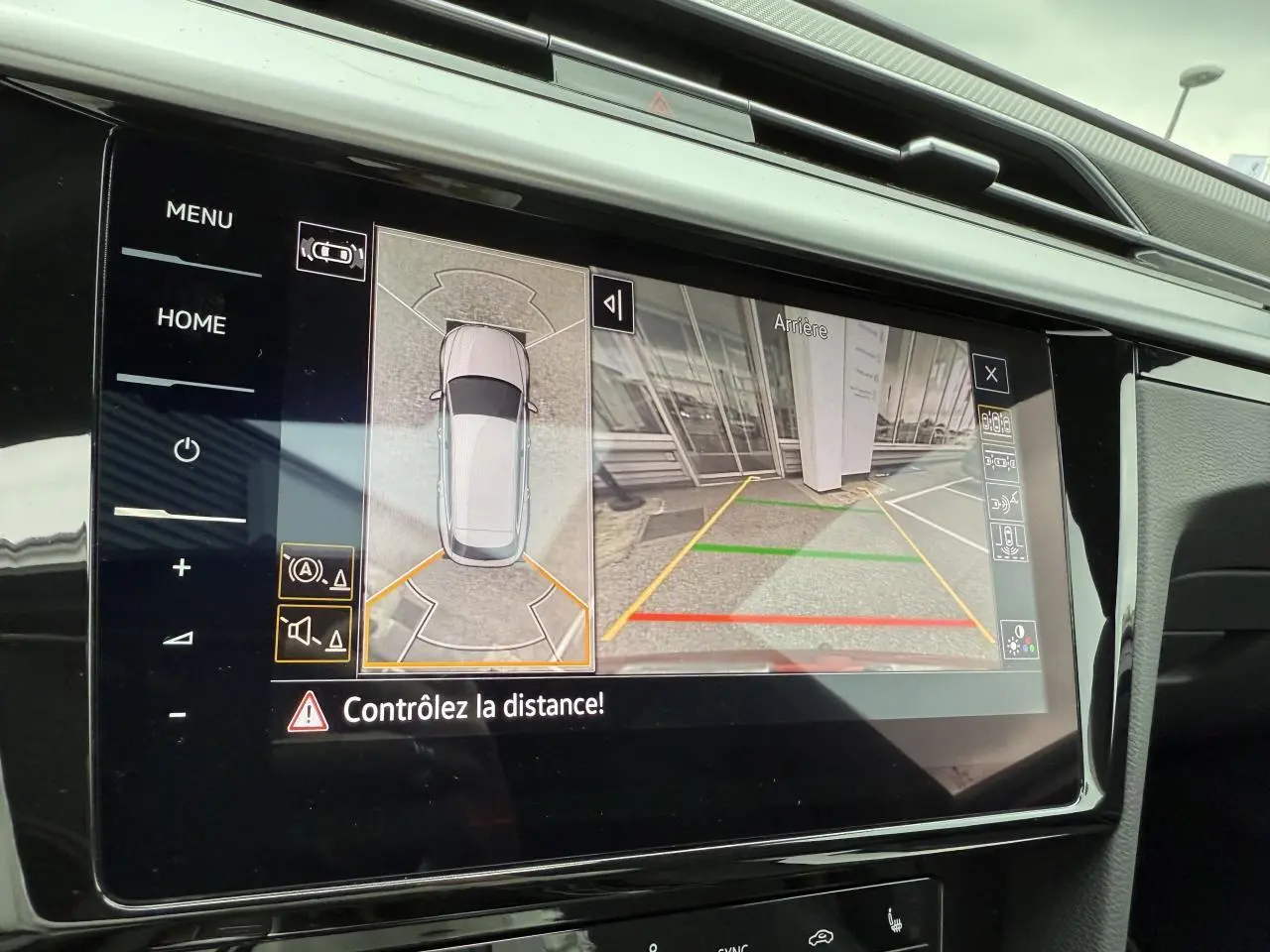 Écran tactile intérieur affichant la caméra de recul et l'aide au stationnement d'une Volkswagen Arteon Shooting Brake Rouge Roi.