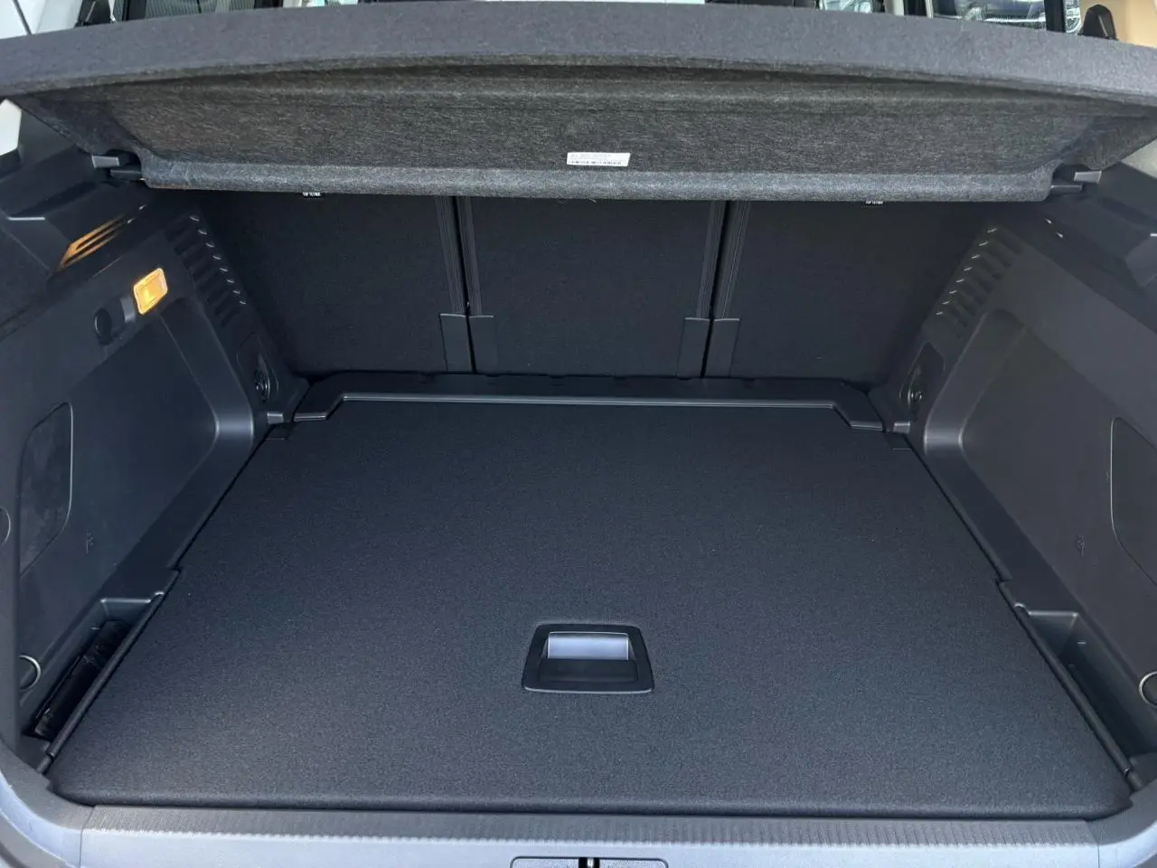 Vue intérieure du coffre ouvert du Citroën C5 Aircross gris Platinium, montrant le plancher modulable et la trappe centrale.