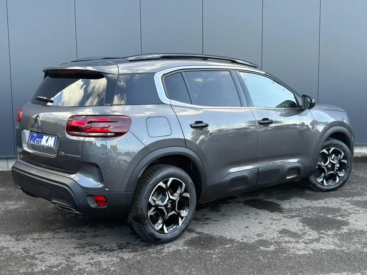 Vue 3/4 arrière droite du Citroën C5 Aircross gris Platinium avec jantes alliage bi-ton et toit ouvrant panoramique.