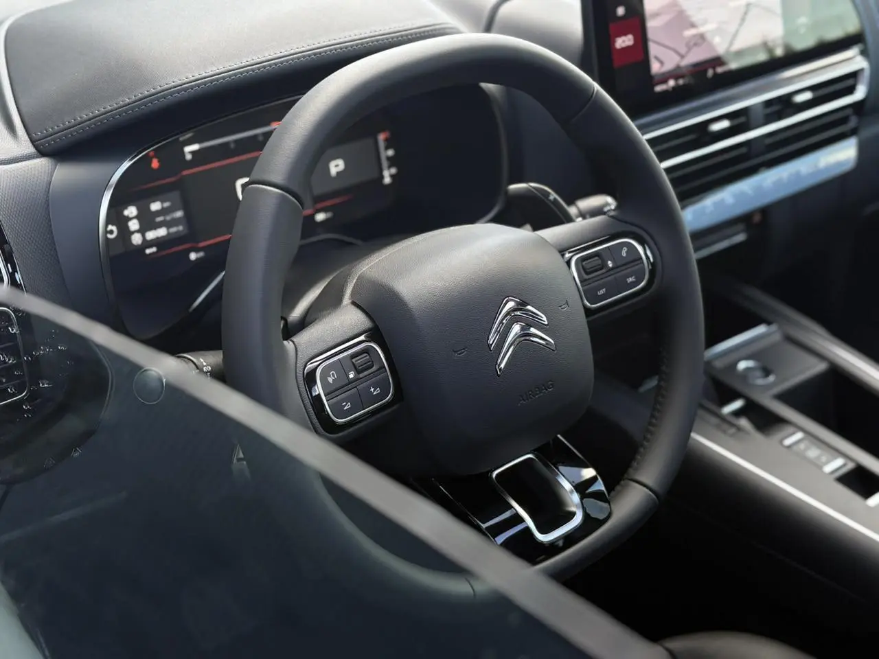 Vue rapprochée du volant noir et du tableau de bord numérique du Citroën C5 Aircross 2025, intérieur moderne et épuré.