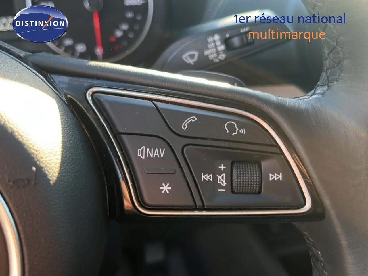 Gros plan sur les commandes audio et navigation au volant cuir noir d'un Audi Q2 35 TFSI S-Line 2023.