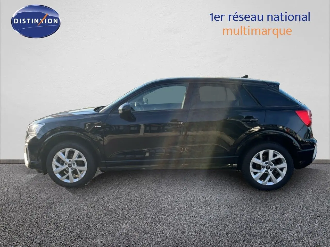 Profil côté gauche d'un Audi Q2 noir mito metal 2023, finition S-Line avec jantes alliage et cinq portes visibles.