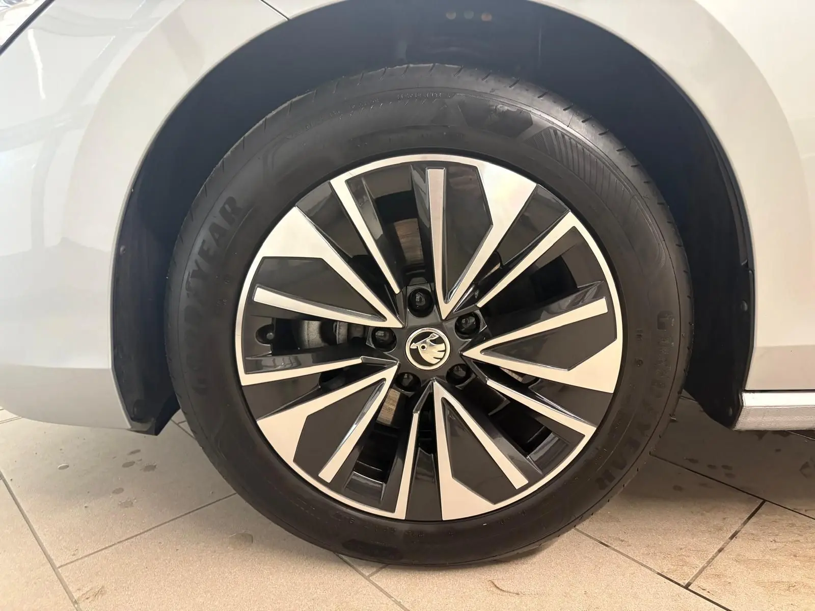 Gros plan sur la roue avant droite d'une Skoda Superb Combi gris argent 2025 avec jante alliage bicolore.