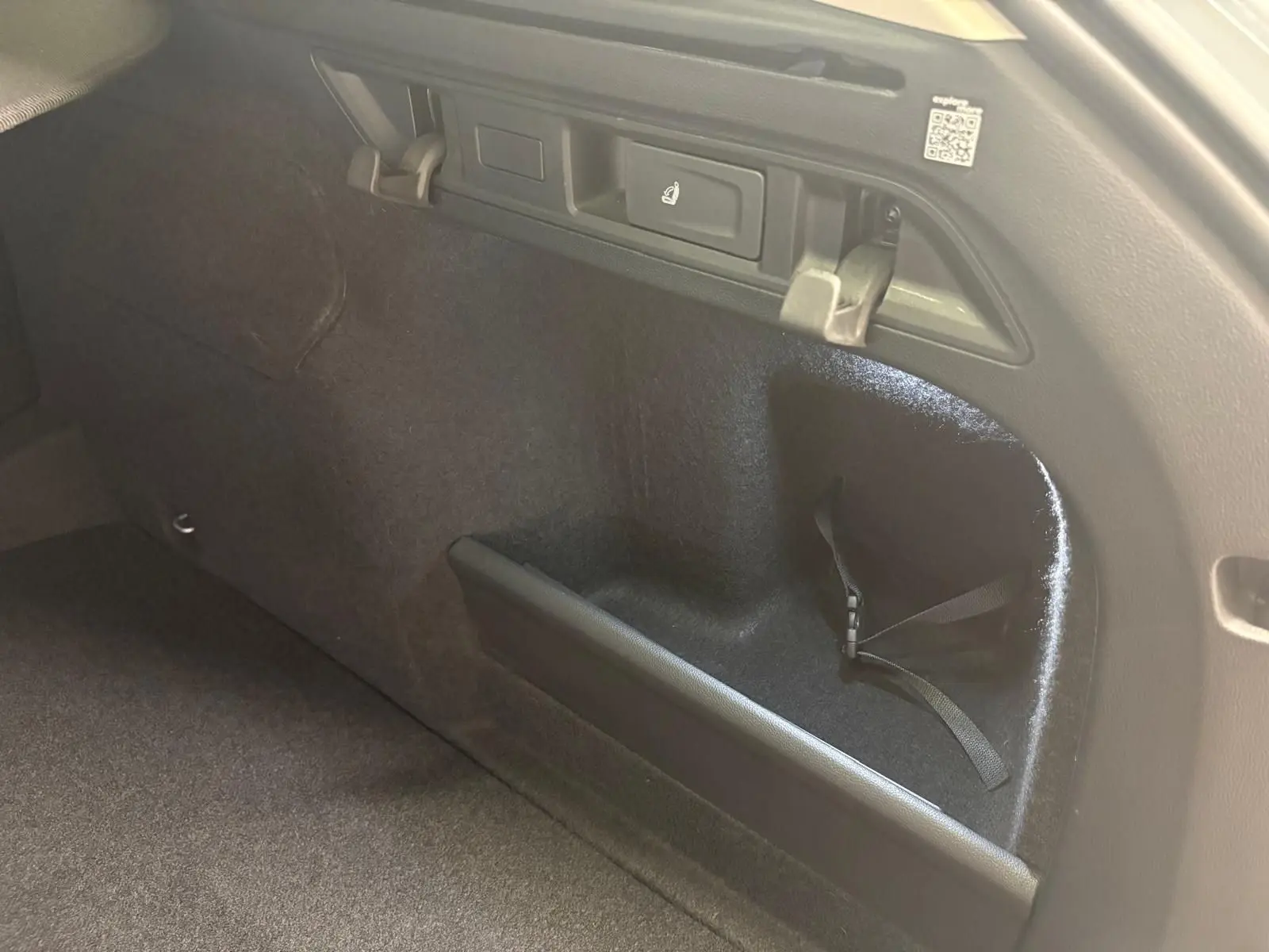 Détail de l’espace de rangement intérieur arrière du coffre du Skoda Superb Combi gris argent 2025, version diesel.