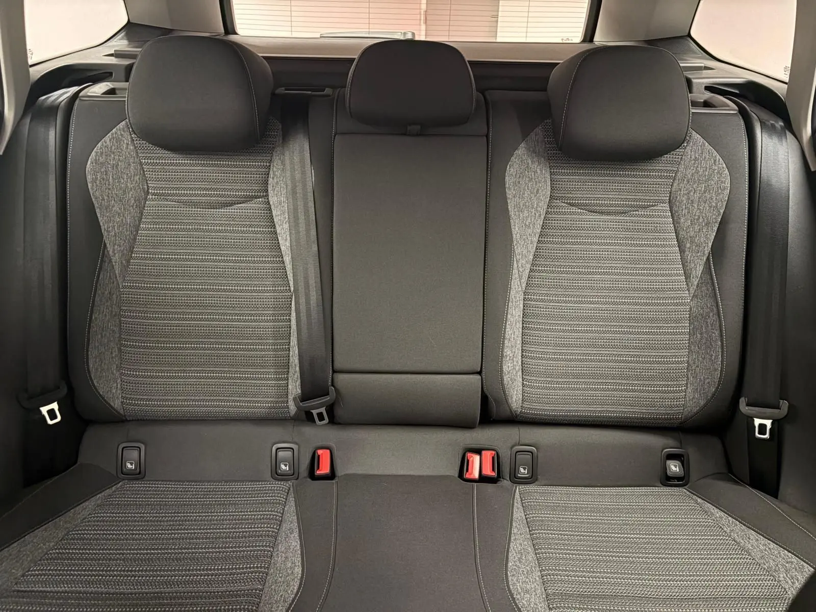 Vue intérieure sur les sièges arrière gris et noirs du Skoda Superb Combi 2025, avec ceintures et appuie-têtes visibles.
