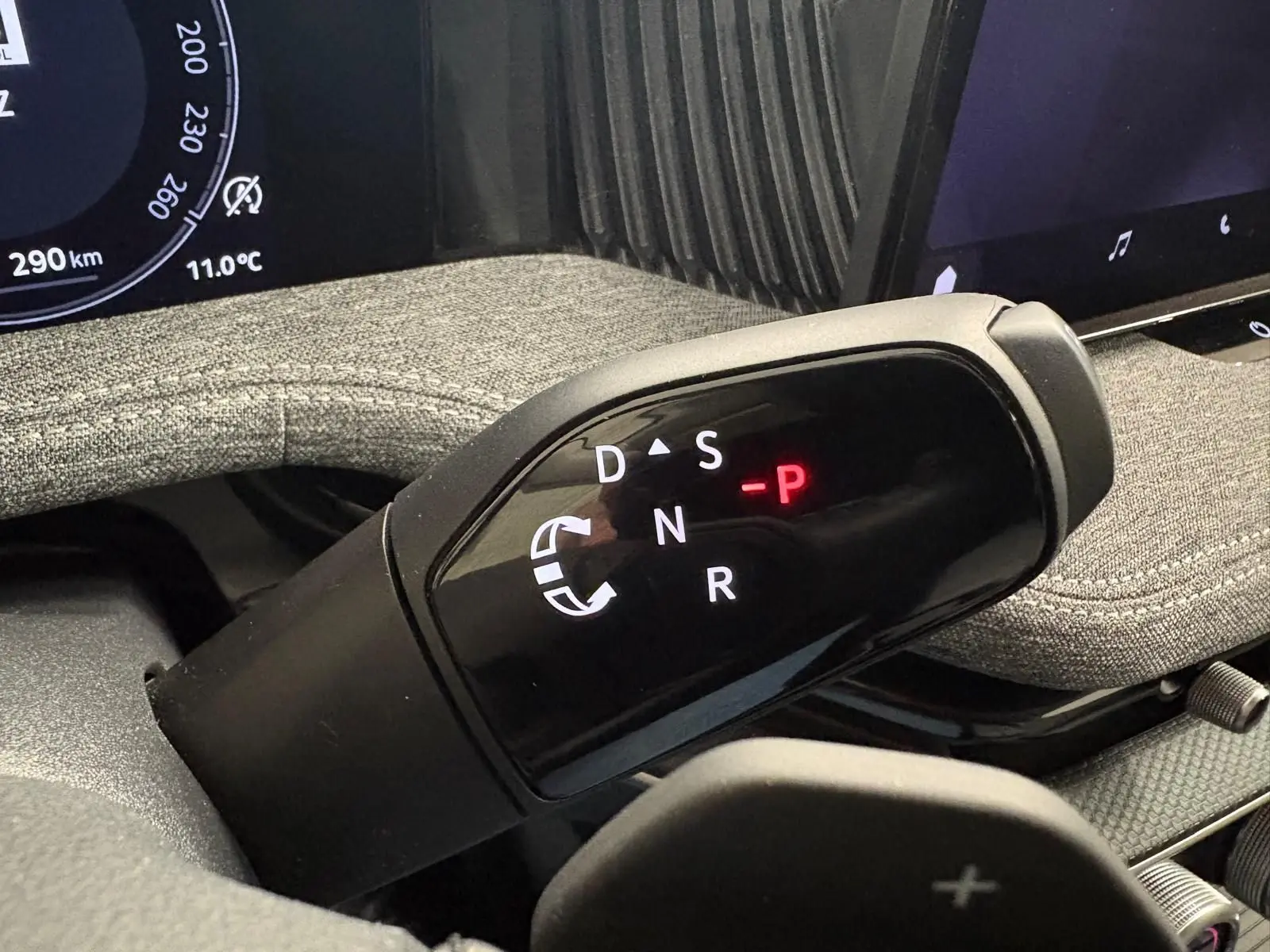 Gros plan sur le levier de vitesses automatique DSG7 du Skoda Superb Combi 2025, intérieur avec tissu gris argent.