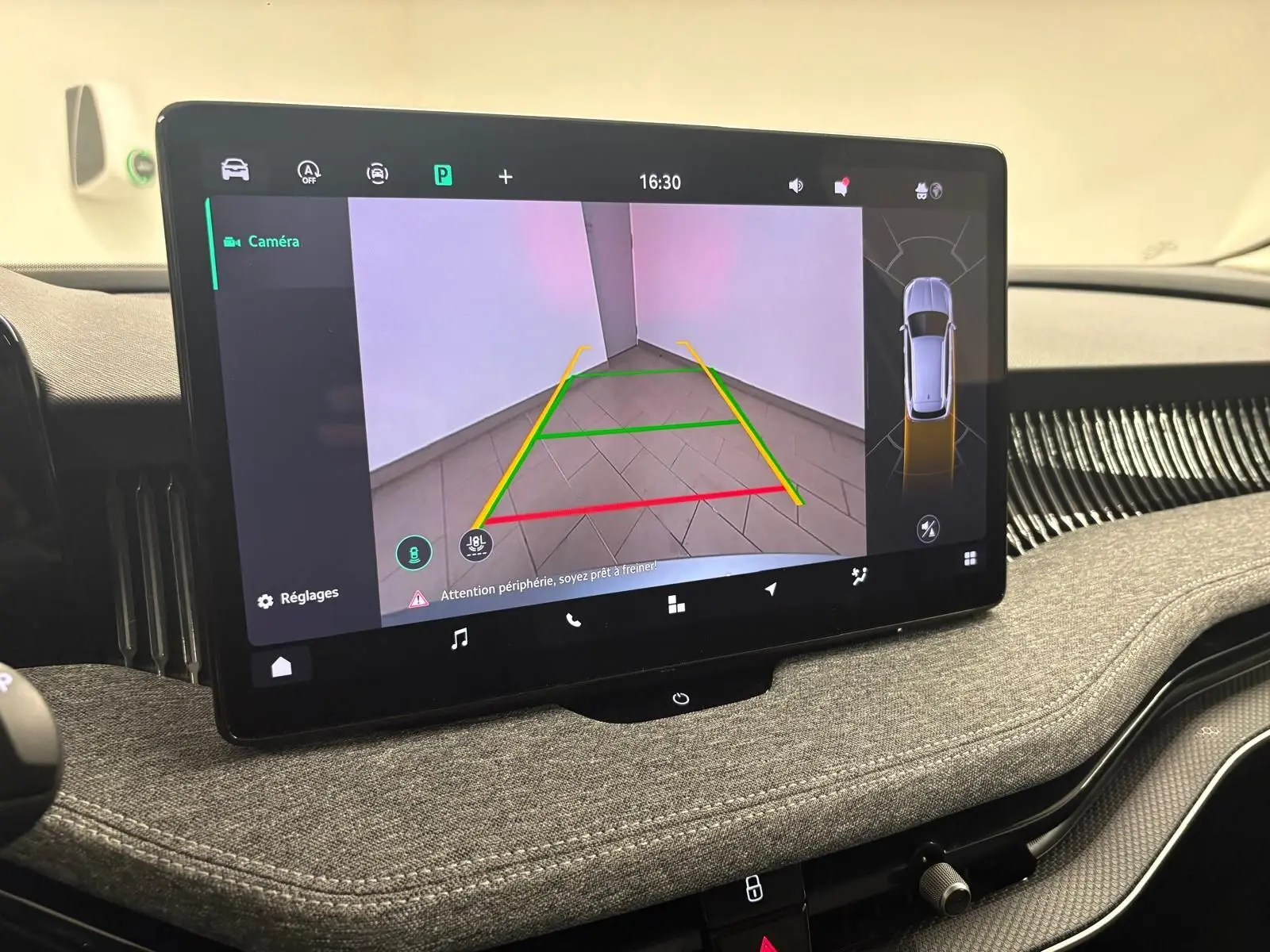 Écran tactile intérieur montrant la caméra de recul avec guidage, tableau de bord gris tissu du Skoda Superb Combi 2025.