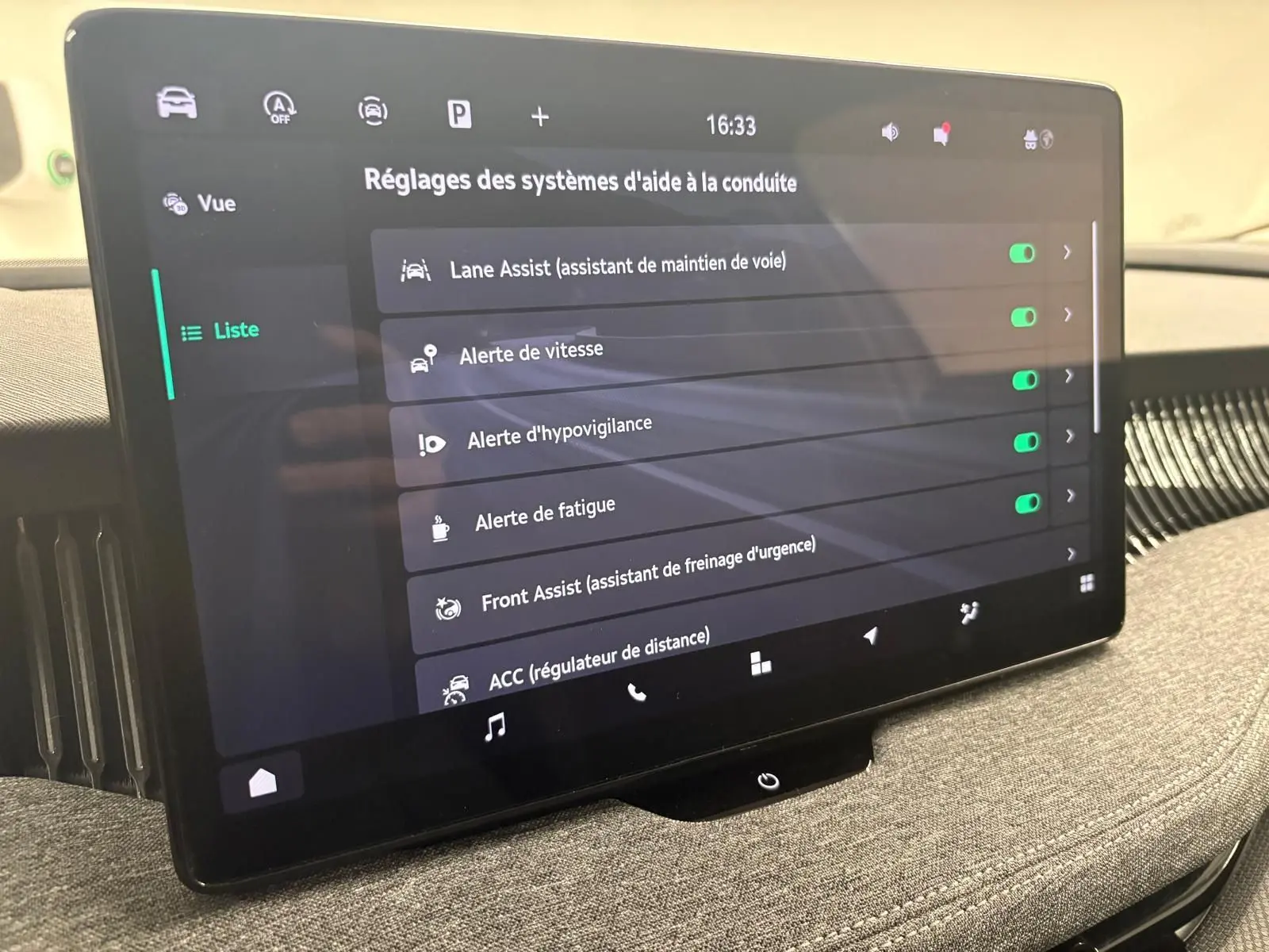 Écran tactile central du Skoda Superb Combi gris argent 2025 affichant les réglages des aides à la conduite.