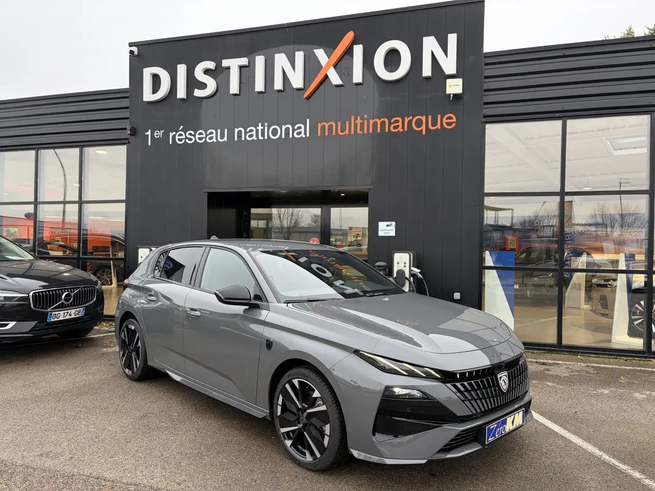 Peugeot 308 gris selenium vue 3/4 avant droit, calandre noire distinctive et jantes alliage bi-ton.