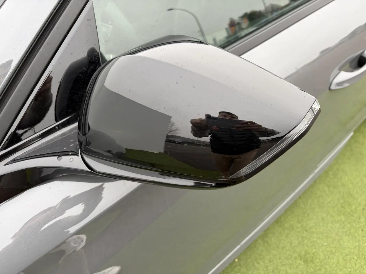 Rétroviseur extérieur droit noir brillant sur Peugeot 308 gris selenium, vue rapprochée côté conducteur.