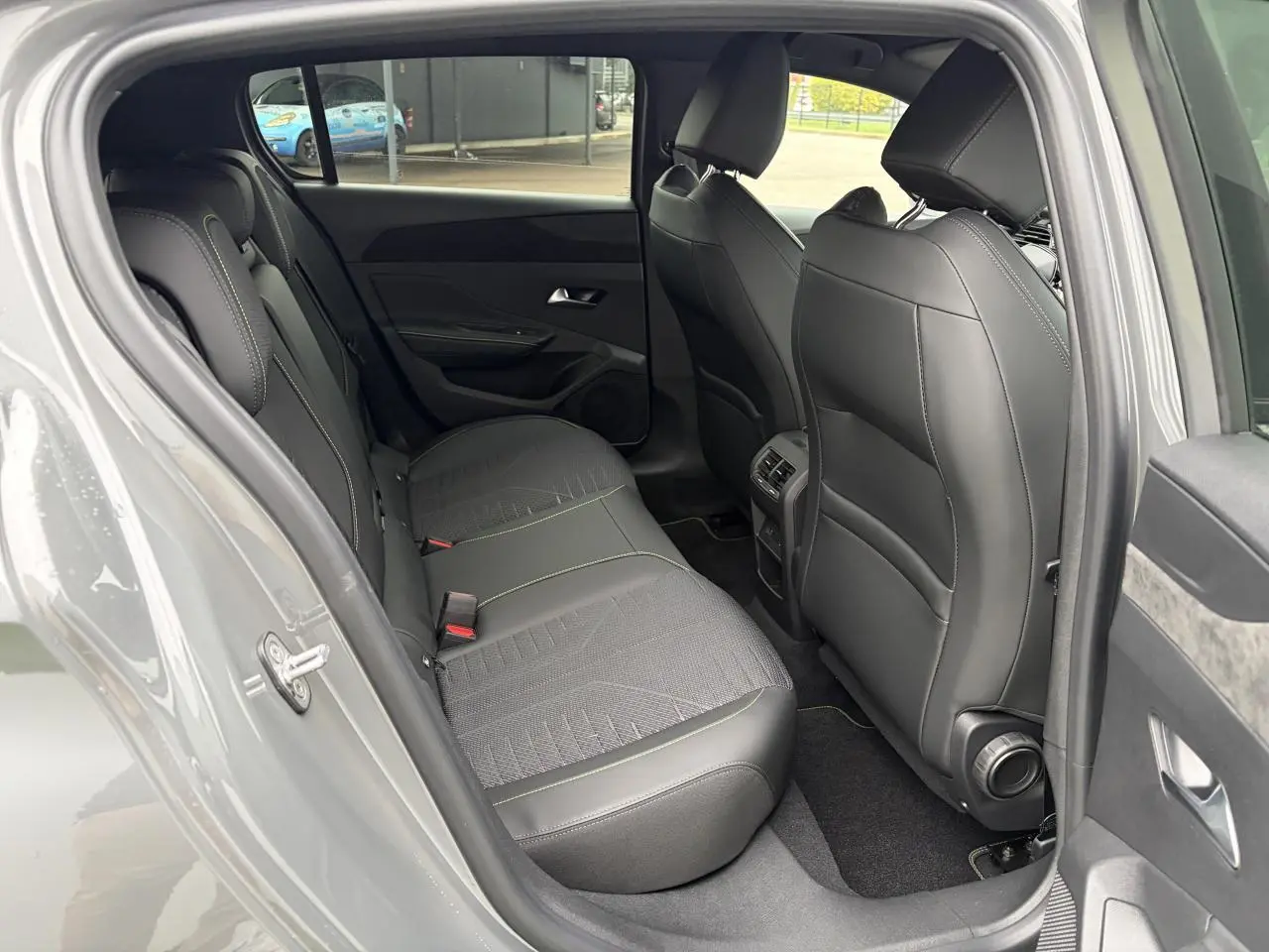 Vue côté gauche de l’habitacle arrière d’une Peugeot 308 gris selenium avec sièges cuir et surpiqûres vert Adamite.