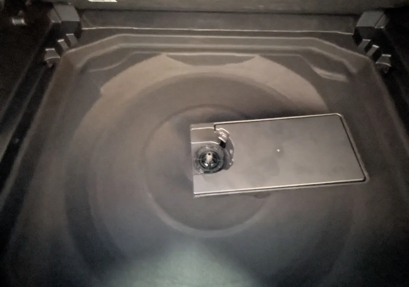 Gros plan sur le coffre noir du Citroën C5 Aircross 2024, montrant la trappe centrale du rangement sous plancher.