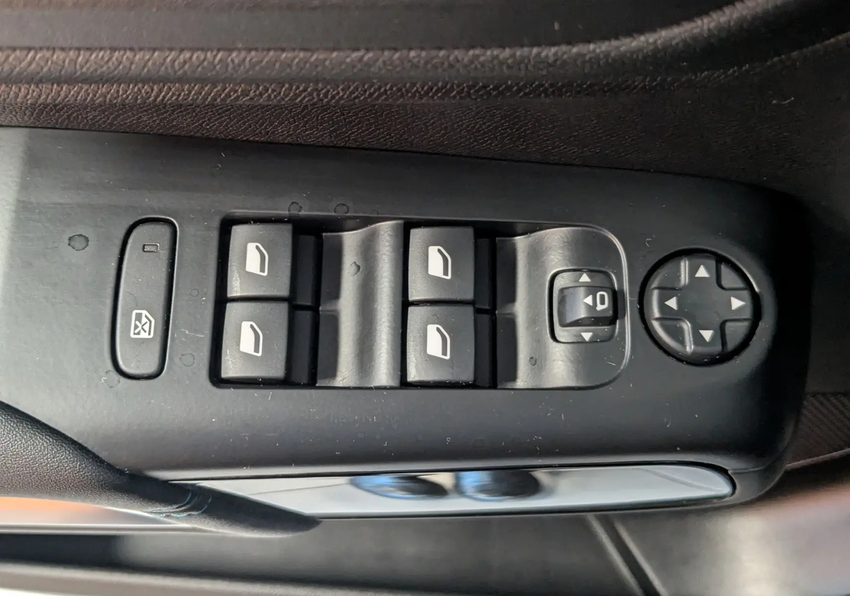 Vue rapprochée des commandes de lève-vitres et réglages des rétroviseurs côté conducteur d'une Citroën C5 Aircross noir 2024.