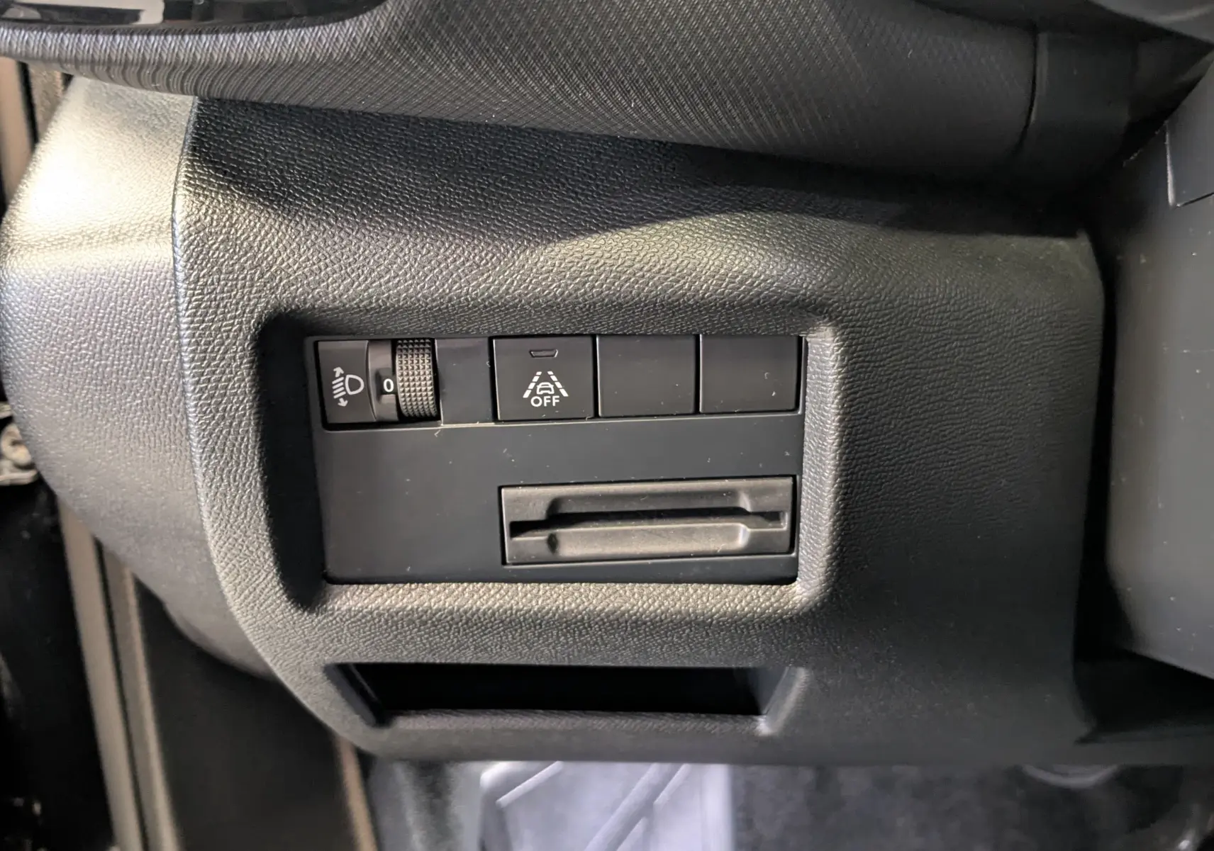 Détail du tableau de bord côté gauche noir du Citroën C5 Aircross 2024 avec commandes d'éclairage et assistance à la conduite.