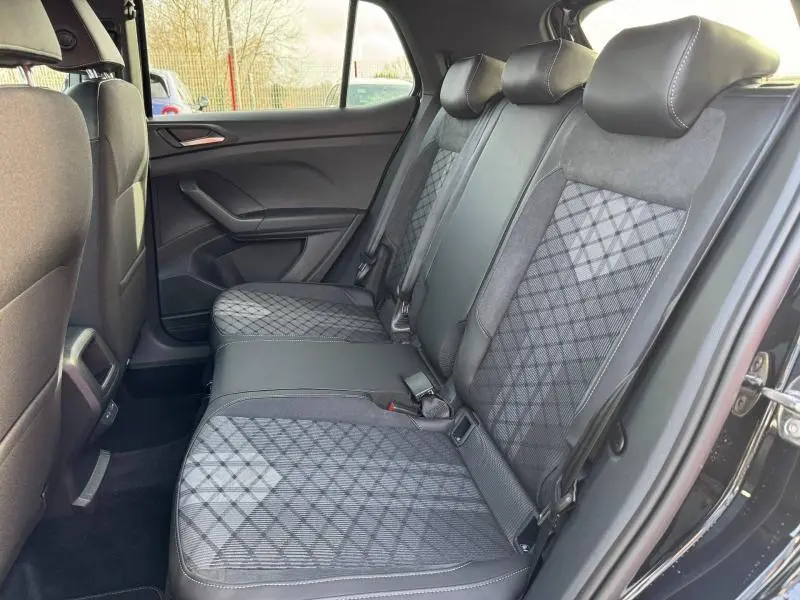 Vue intérieure côté droit des sièges arrière du Volkswagen T-Cross 2025 noir intense nacré avec sellerie tissu et cuir R-Line.