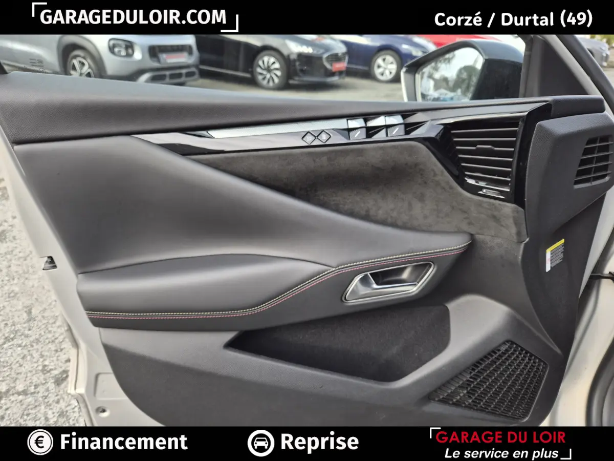 Vue intérieure côté droit de la porte avant beige du DS4 2024 avec garniture cuir noir et surpiqûres rouges.