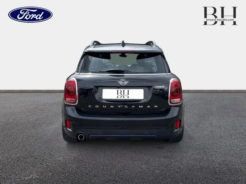 Vue arrière d'une MINI Countryman Cooper D 150ch Midnight Black avec feux LED et sortie d'échappement chromée côté gauche.