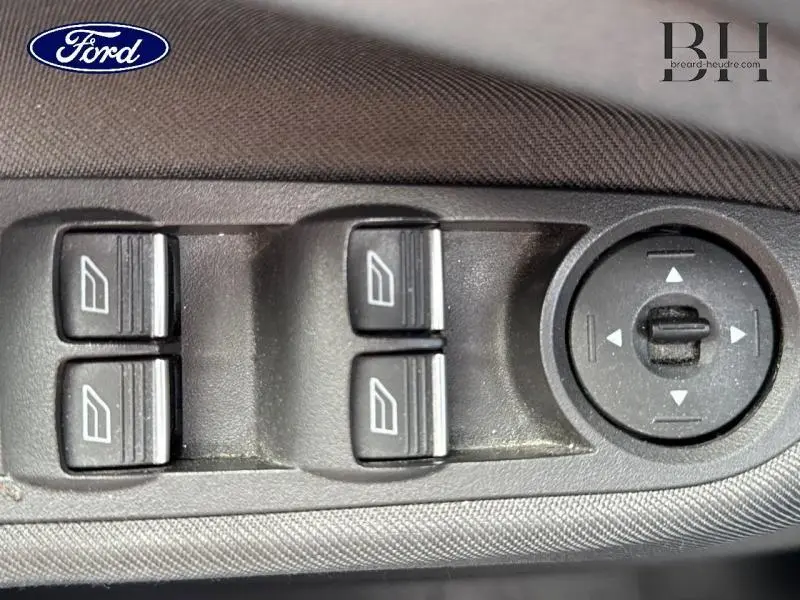 Gros plan sur les commandes de lève-vitres et réglage des rétroviseurs côté conducteur d'un Ford C-MAX blanc Glacier 2019.