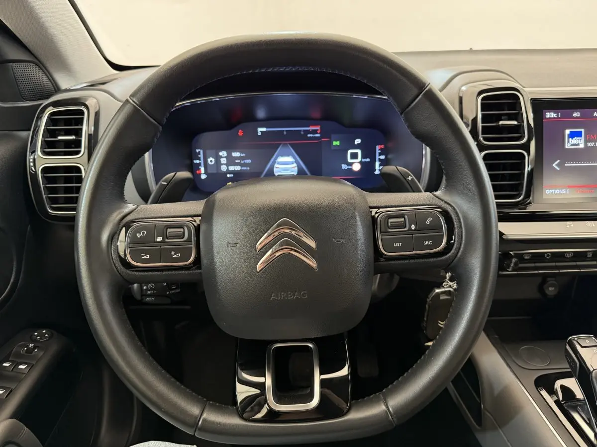 Vue rapprochée du volant cuir noir du Citroën C5 Aircross 2020 avec tableau de bord numérique et écran tactile.