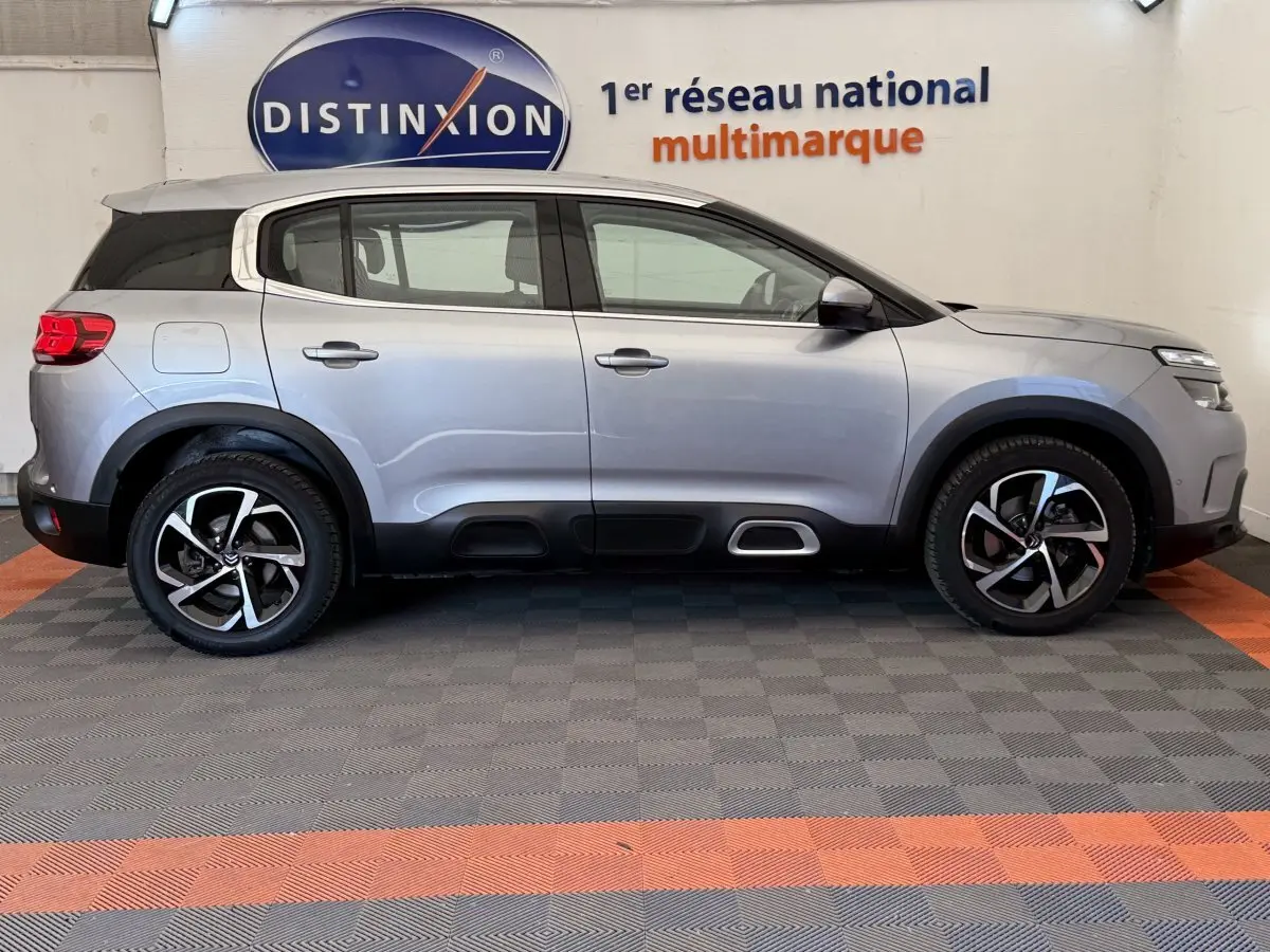 Profil côté gauche d'un Citroën C5 Aircross gris clair 2020 avec jantes alliage et détails noirs contrastants.