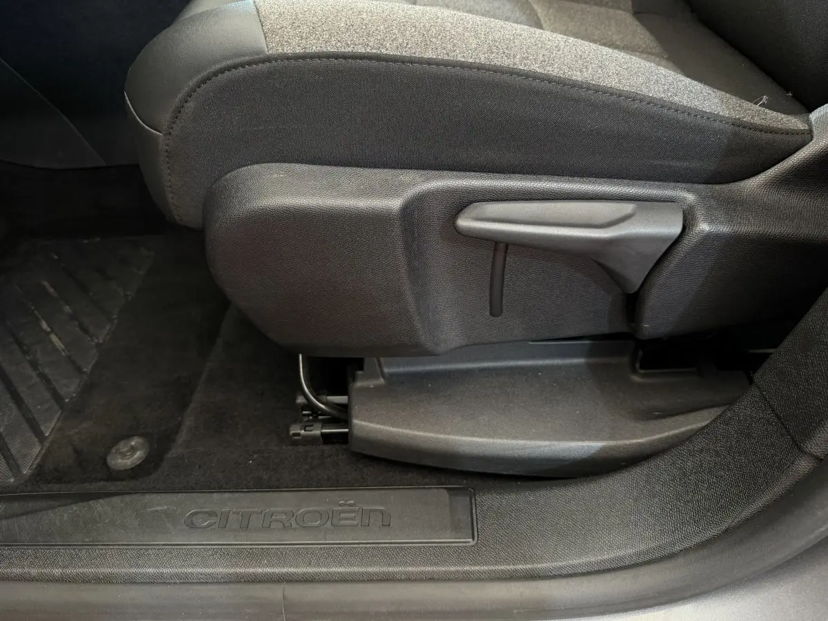 Détail côté gauche du siège avant noir et seuil de porte avec logo Citroën dans un C5 Aircross gris clair 2020.