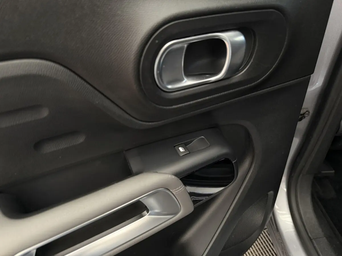 Gros plan sur la porte avant droite gris clair du Citroën C5 Aircross avec poignée et commande de vitre noire.