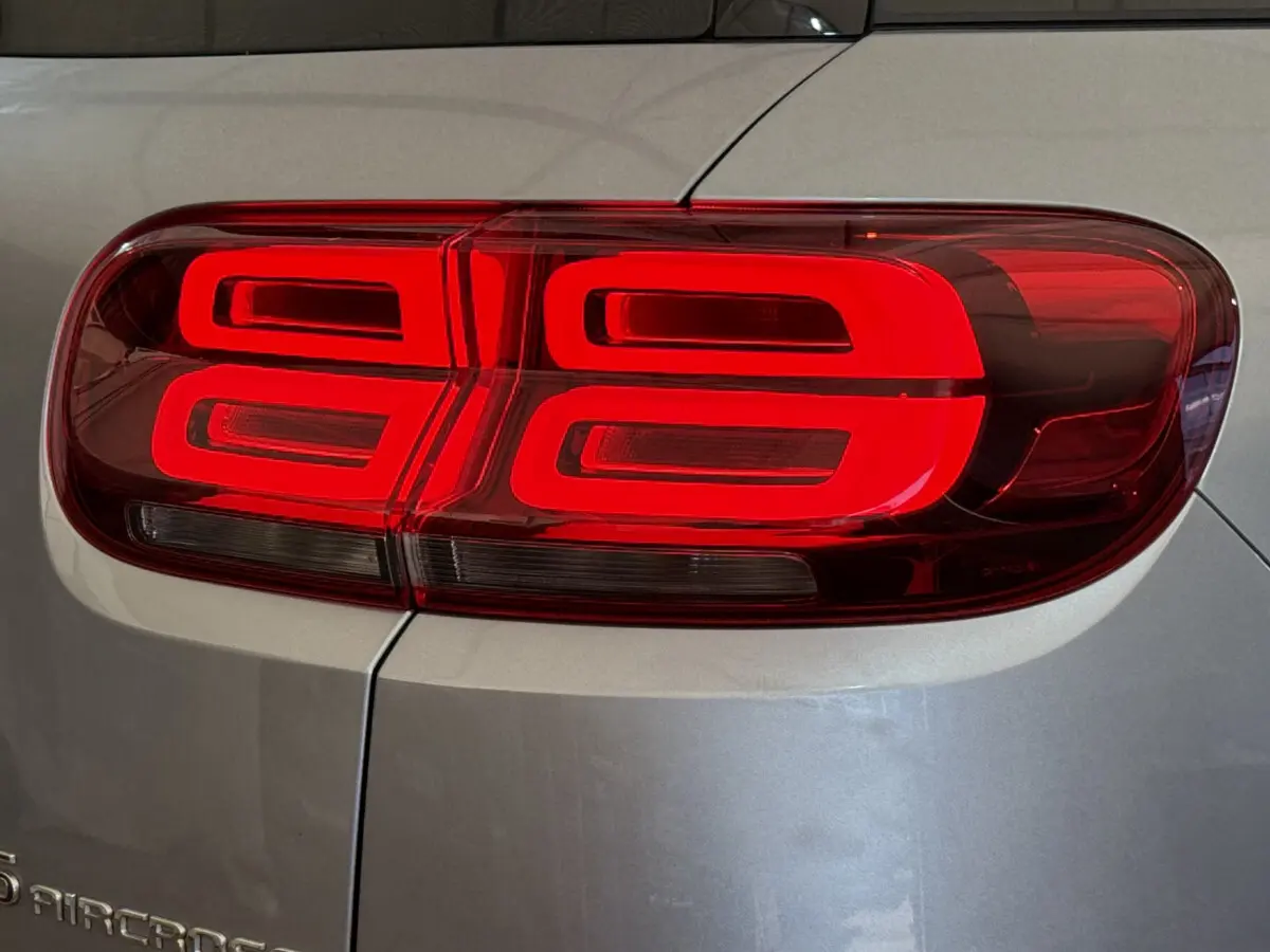 Gros plan sur le feu arrière droit rouge du Citroën C5 Aircross gris clair, soulignant son design lumineux distinctif.