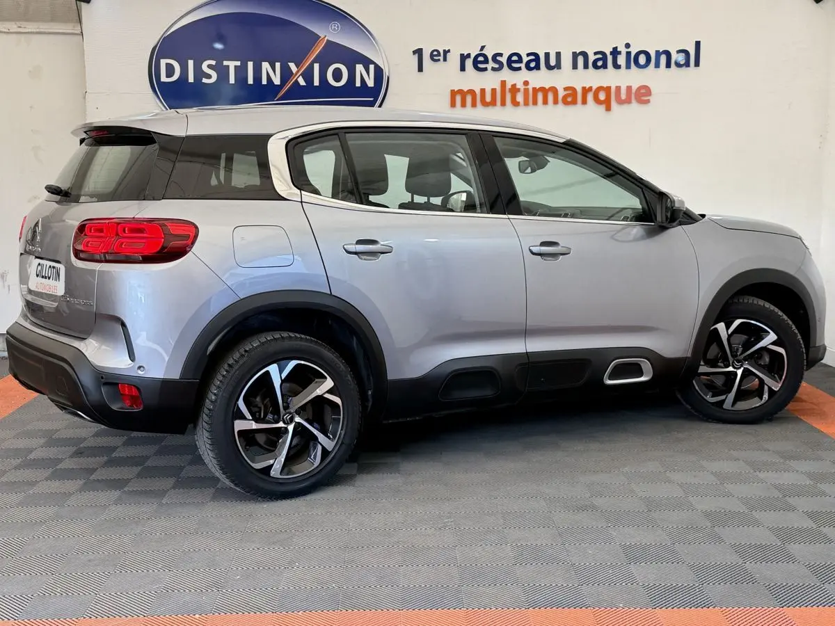 Profil droit du Citroën C5 Aircross gris clair 2020 avec jantes alliage et protections noires sur bas de caisse.