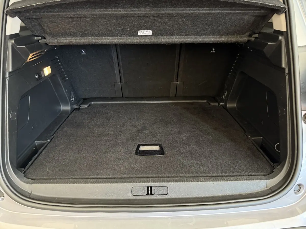 Coffre ouvert vu de l'arrière d'un Citroën C5 Aircross gris clair, espace de chargement propre et vide.