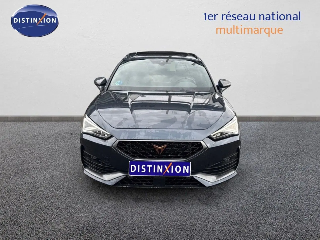 Vue frontale d'une CUPRA LEON ST 1.5 ETSI 150CH DSG 2024 en gris magnetic metal avec calandre noire et logo CUPRA cuivré.