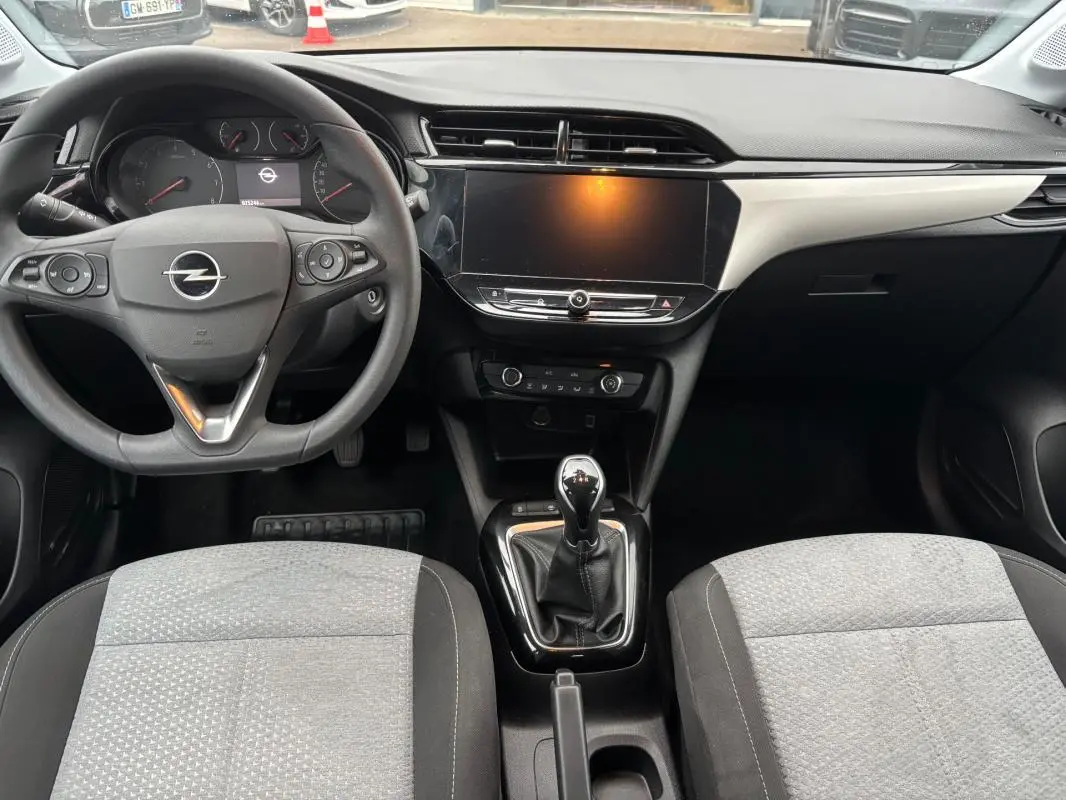 Vue intérieure avant de l’Opel Corsa gris clair 2024, montrant le volant multifonctions, la boîte manuelle et l’écran tactile central.