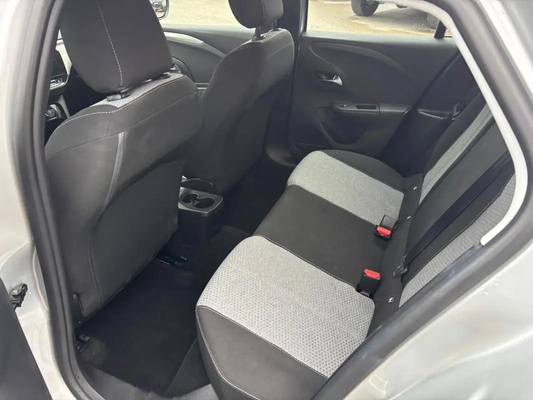 Vue intérieure côté arrière droit de l’Opel Corsa gris clair 2024, sièges arrière bicolores tissu et noir.