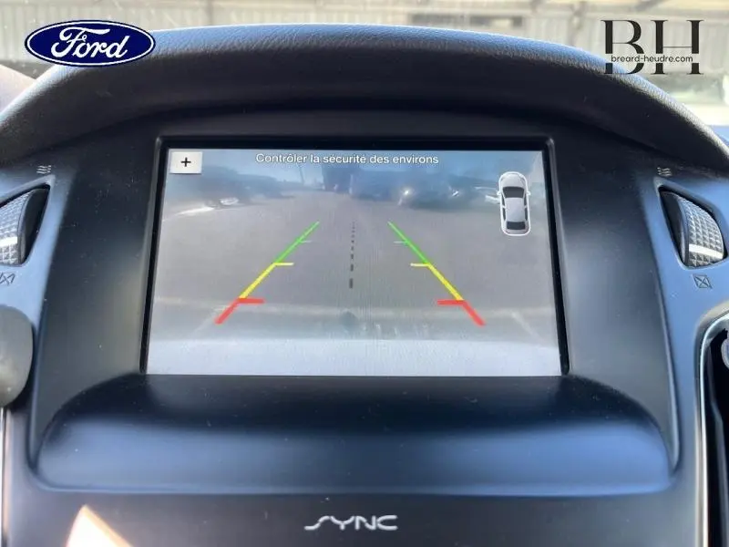 Écran central de la Ford Focus blanc montrant l'affichage de la caméra de recul avec guidage coloré.