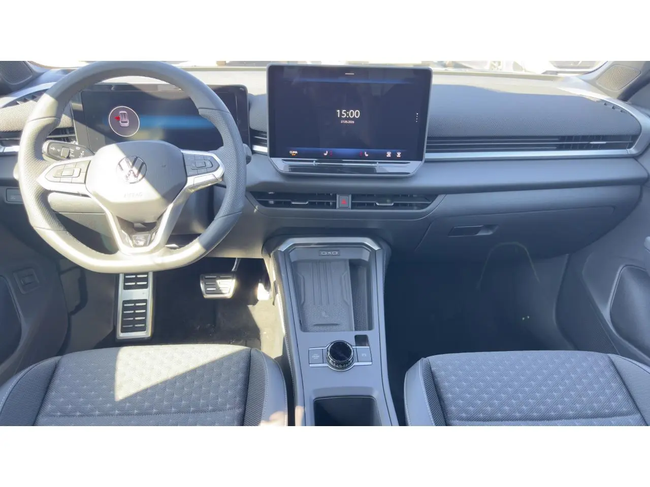 Intérieur du Volkswagen T-Roc noir, vue frontale du poste de conduite avec volant multifonction et écran tactile central.