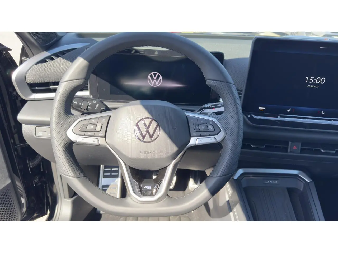 Vue intérieure centrée sur le volant cuir multifonction noir du Volkswagen T-Roc 2026 avec écran digital et console moderne.