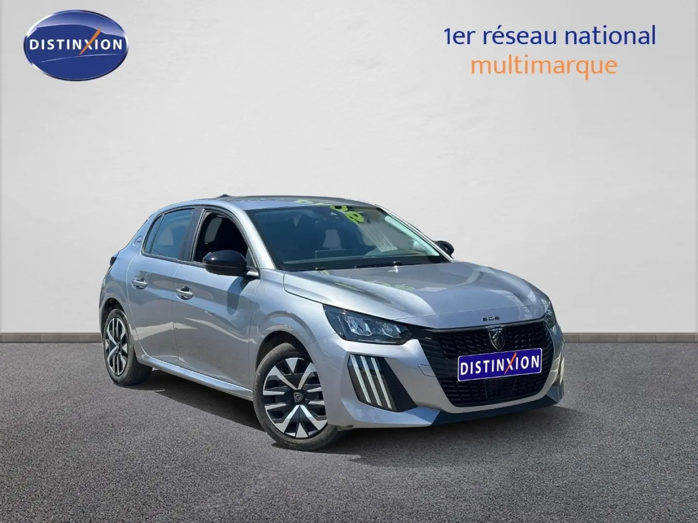 Peugeot 208 gris Artense vue 3/4 avant droit avec jantes et calandre noire distinctive.