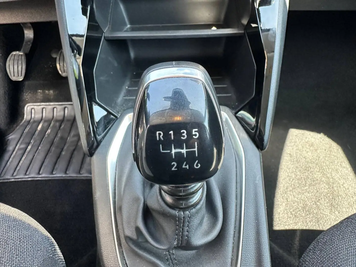 Gros plan sur le levier de vitesses manuel noir de la Peugeot 208 gris Artense, entouré de l’intérieur noir.