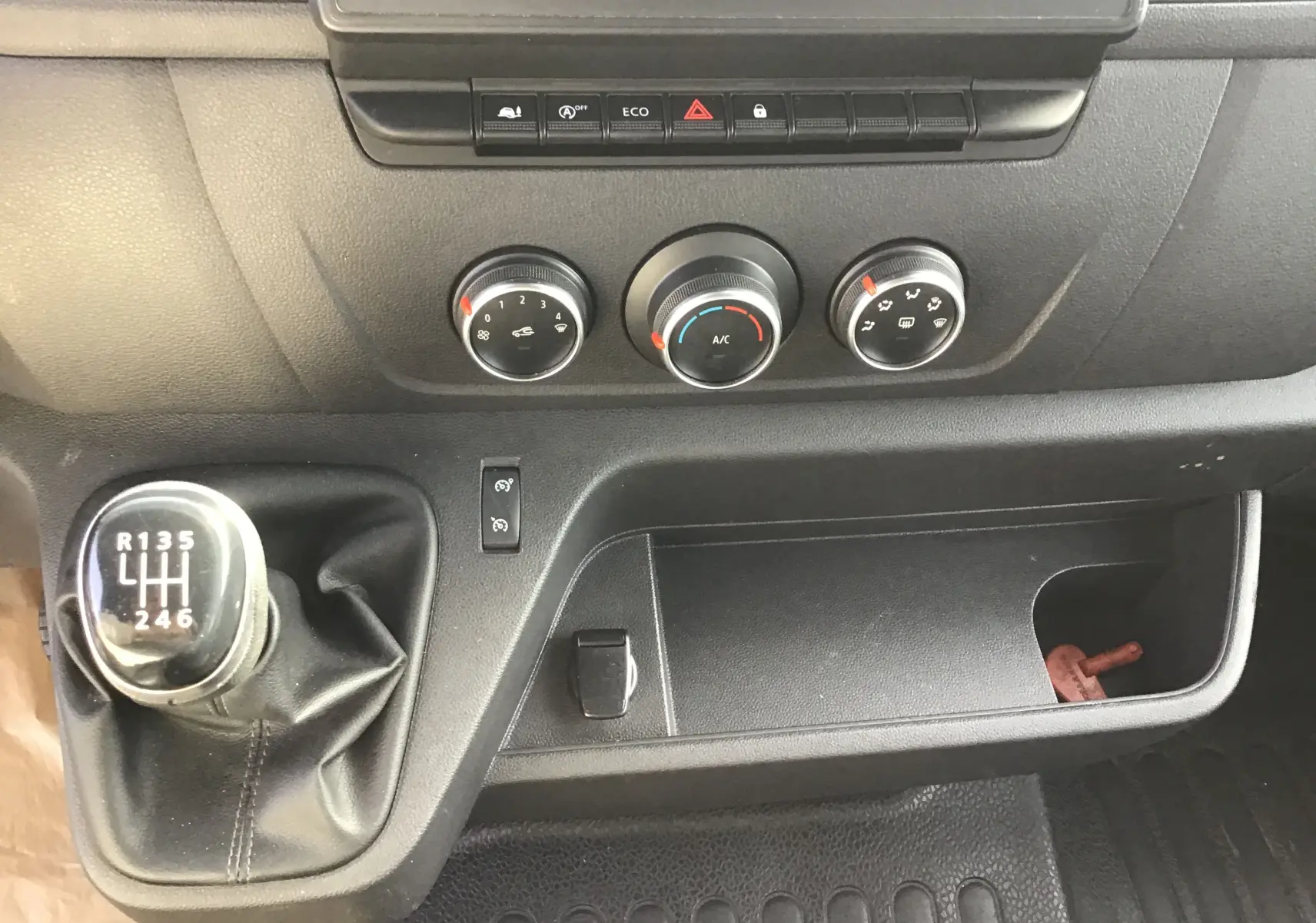 Vue rapprochée de la console centrale de l’Opel Movano L3H1 2020, avec levier de vitesses manuel et commandes de climatisation.