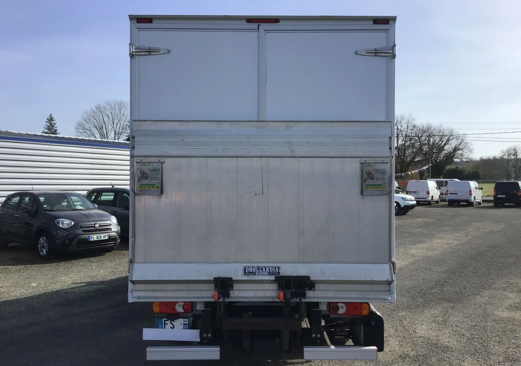 Vue arrière d'un utilitaire blanc Opel Movano Châssis Cabine 2020 avec hayon élévateur et caisse fermée.