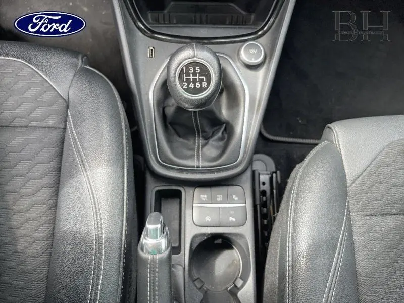 Vue plongeante sur la console centrale du Ford Puma 2022, montrant la boîte manuelle et les sièges en tissu gris.