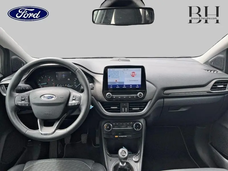 Intérieur avant du Ford Puma 2022, tableau de bord noir avec écran tactile et volant multifonction, boîte manuelle visible.